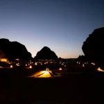 Experience the magical desert landscape of AlUla at dusk, beautifully lit by lanterns.