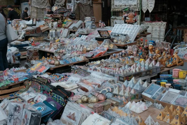 Colorful stalls with Egyptian souvenirs at a bustling market, showcasing local crafts and decor.