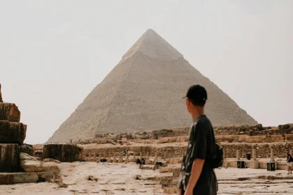 Tourist observing the majestic Great Pyramid of Giza on a sunny day, Egypt.