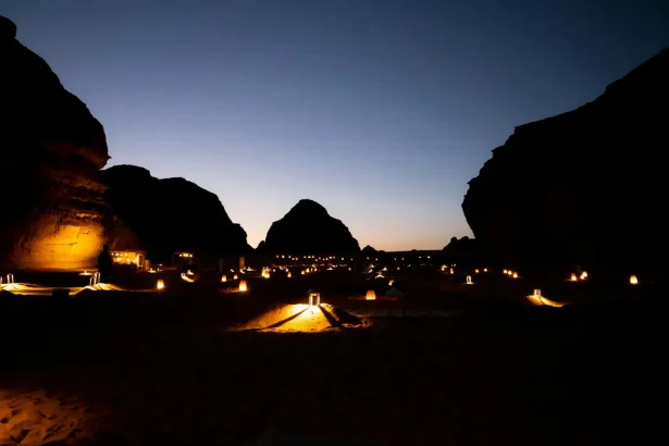 Experience the magical desert landscape of AlUla at dusk, beautifully lit by lanterns.