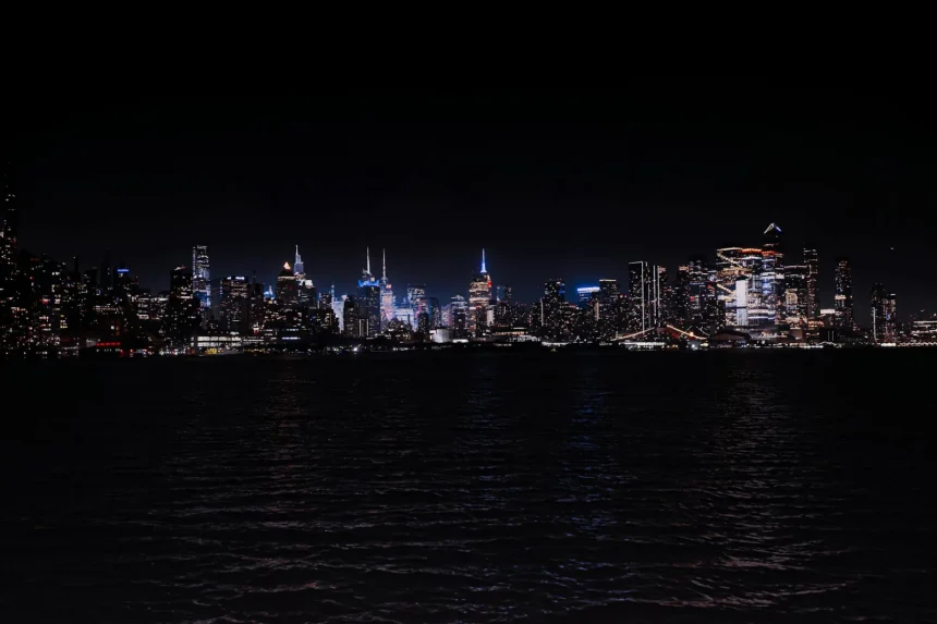 Breathtaking night view of the illuminated New York City skyline across the water.