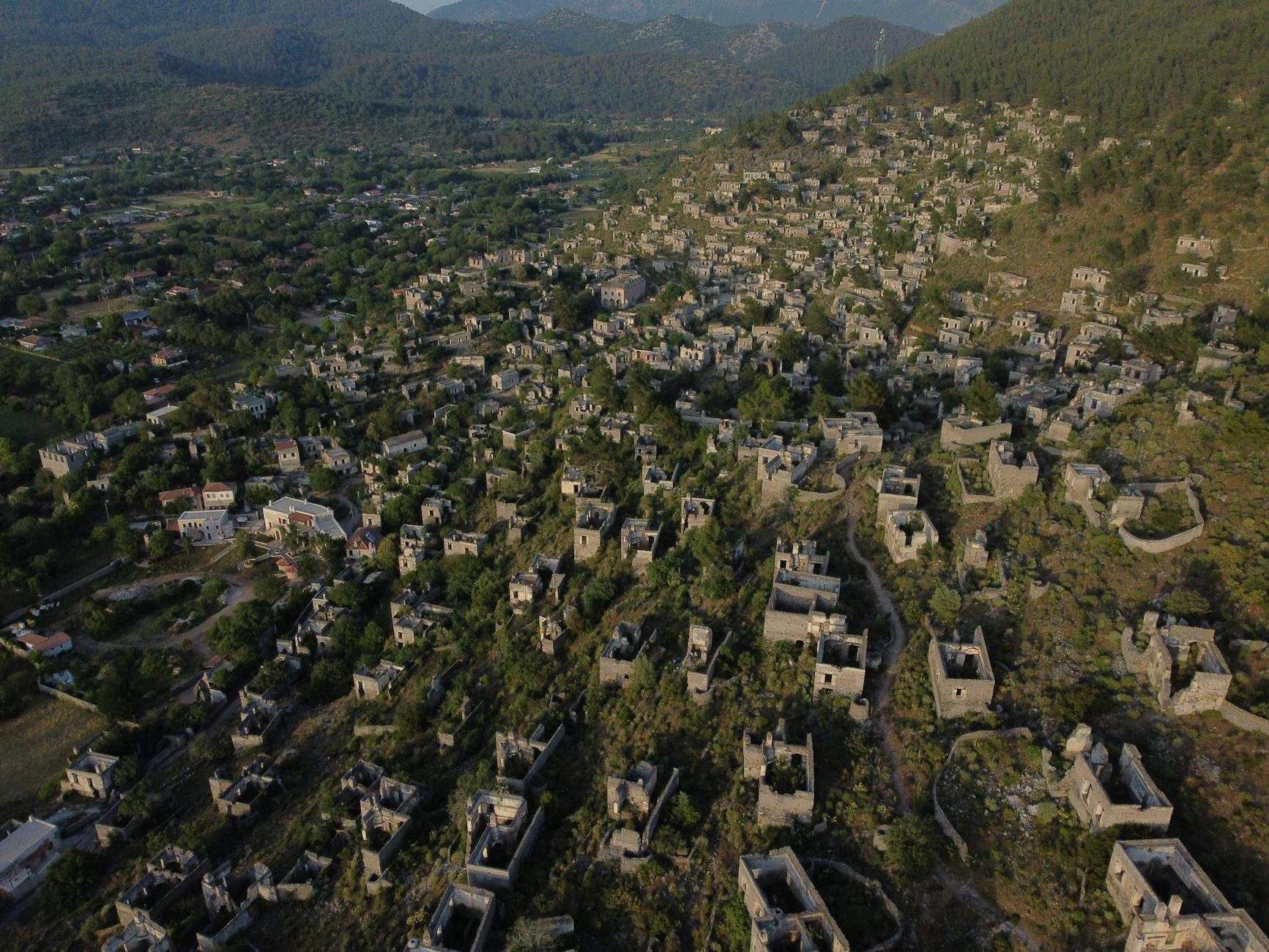Explore the abandoned stone houses of Kayaköy Ghost Town in Fethiye, Turkey from above.