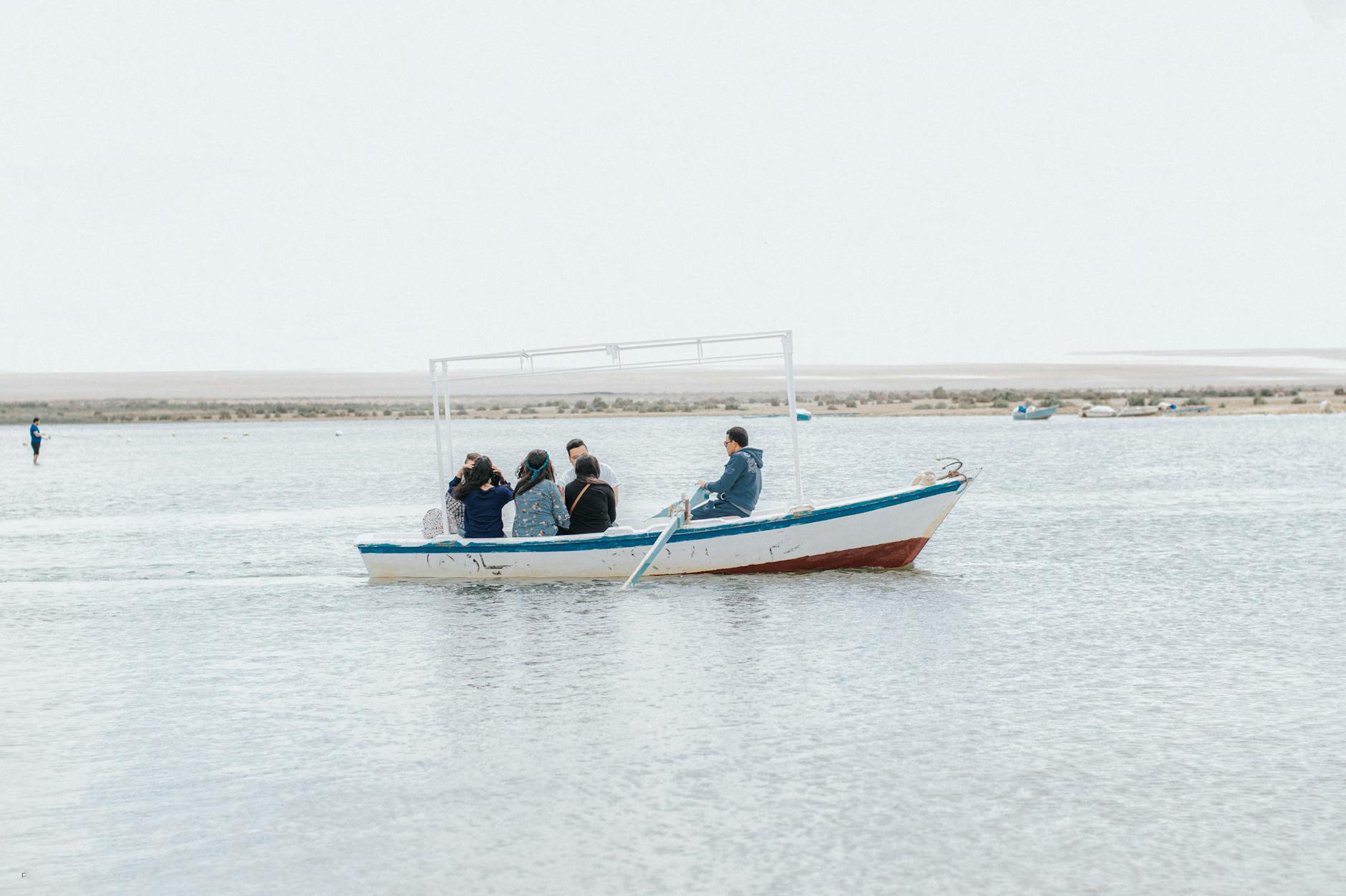 A group enjoys a peaceful boat ride on the tranquil waters of Faiyum Oasis.