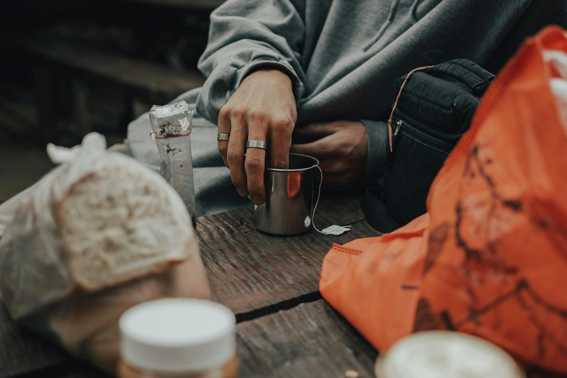 A person prepares tea during a relaxed outdoor camping breakfast.