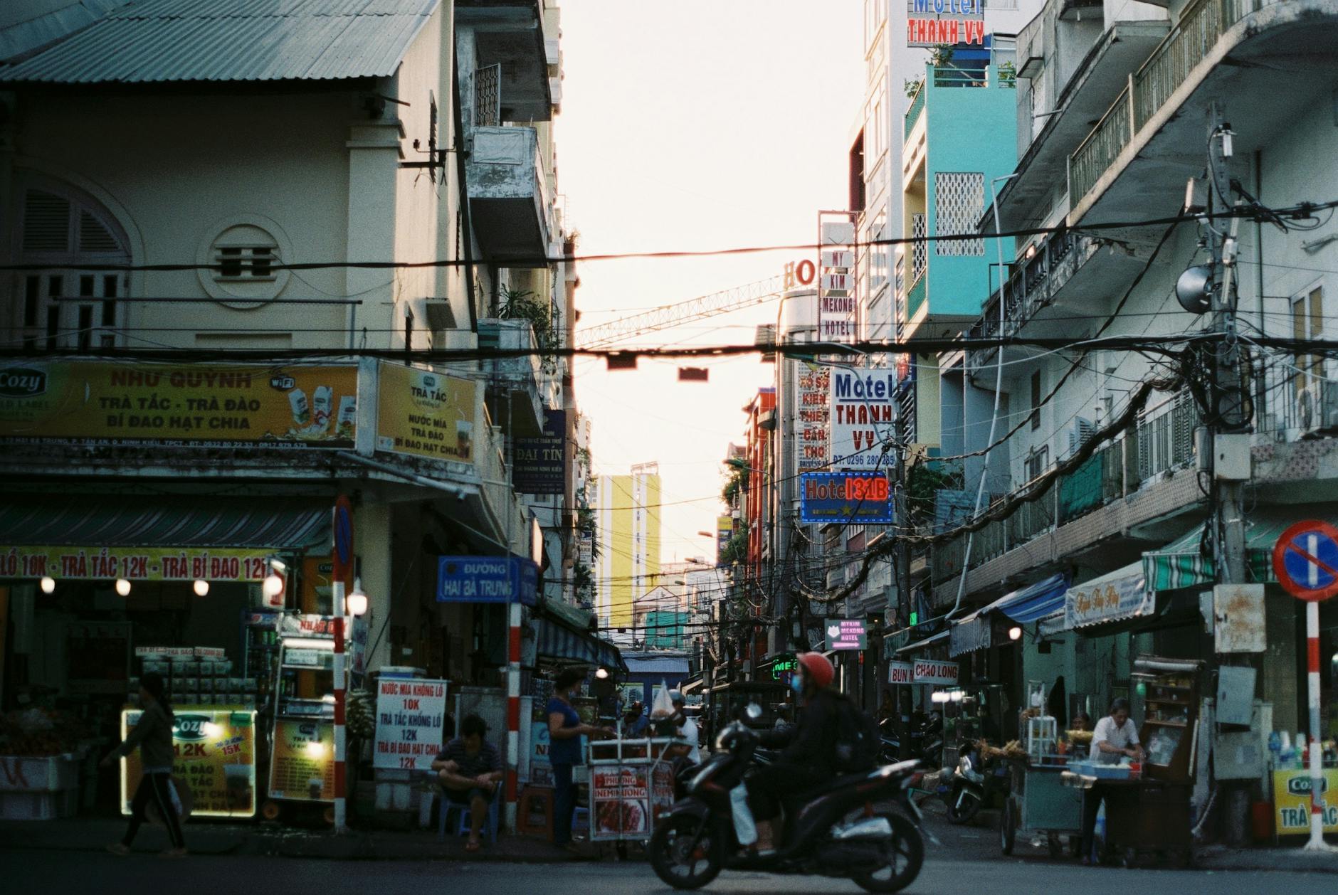 Colorful busy street scene in Cần Thơ, Vietnam with vibrant signs and people.