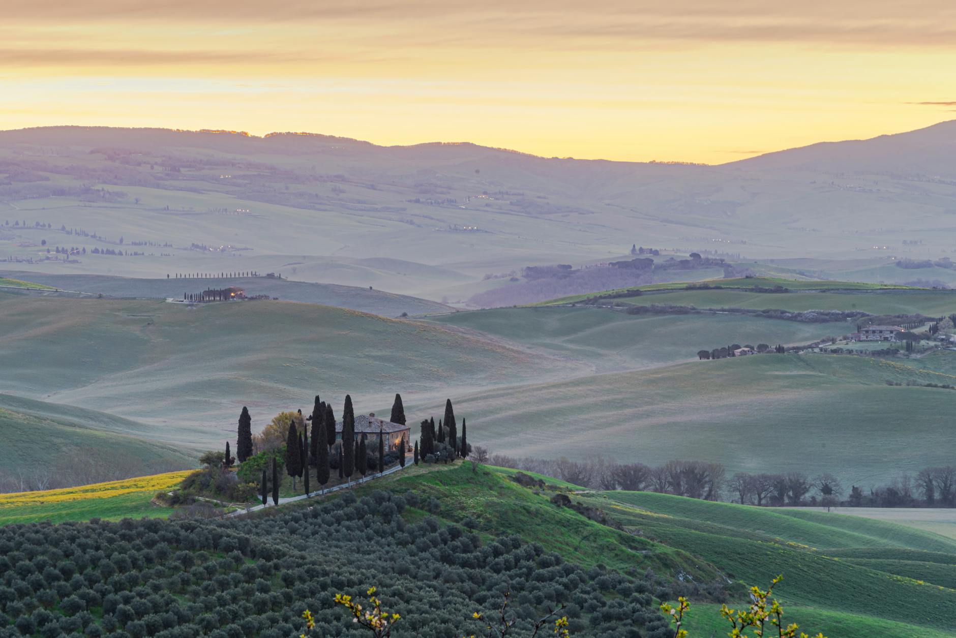 Captivating view of Tuscany's rolling hills and cypress trees at sunrise.