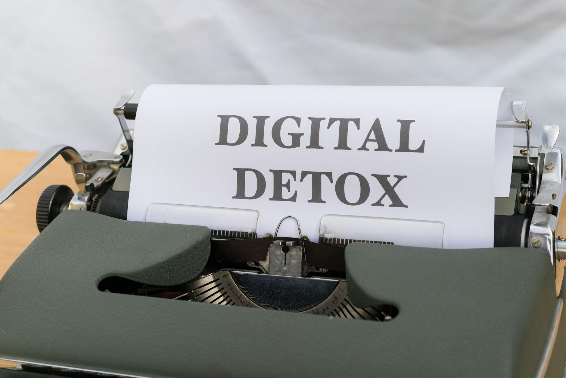 Close-up of a typewriter with paper showing 'Digital Detox', emphasizing a tech-free lifestyle.