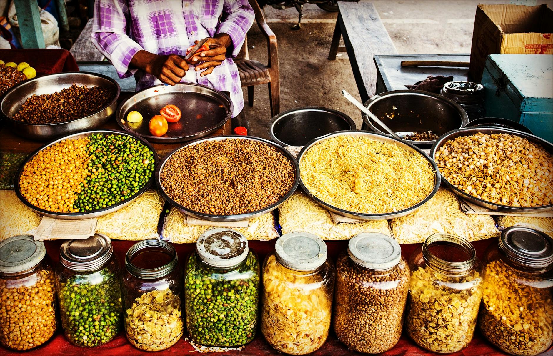 Colorful display of spices and legumes in a traditional Indian street market.
