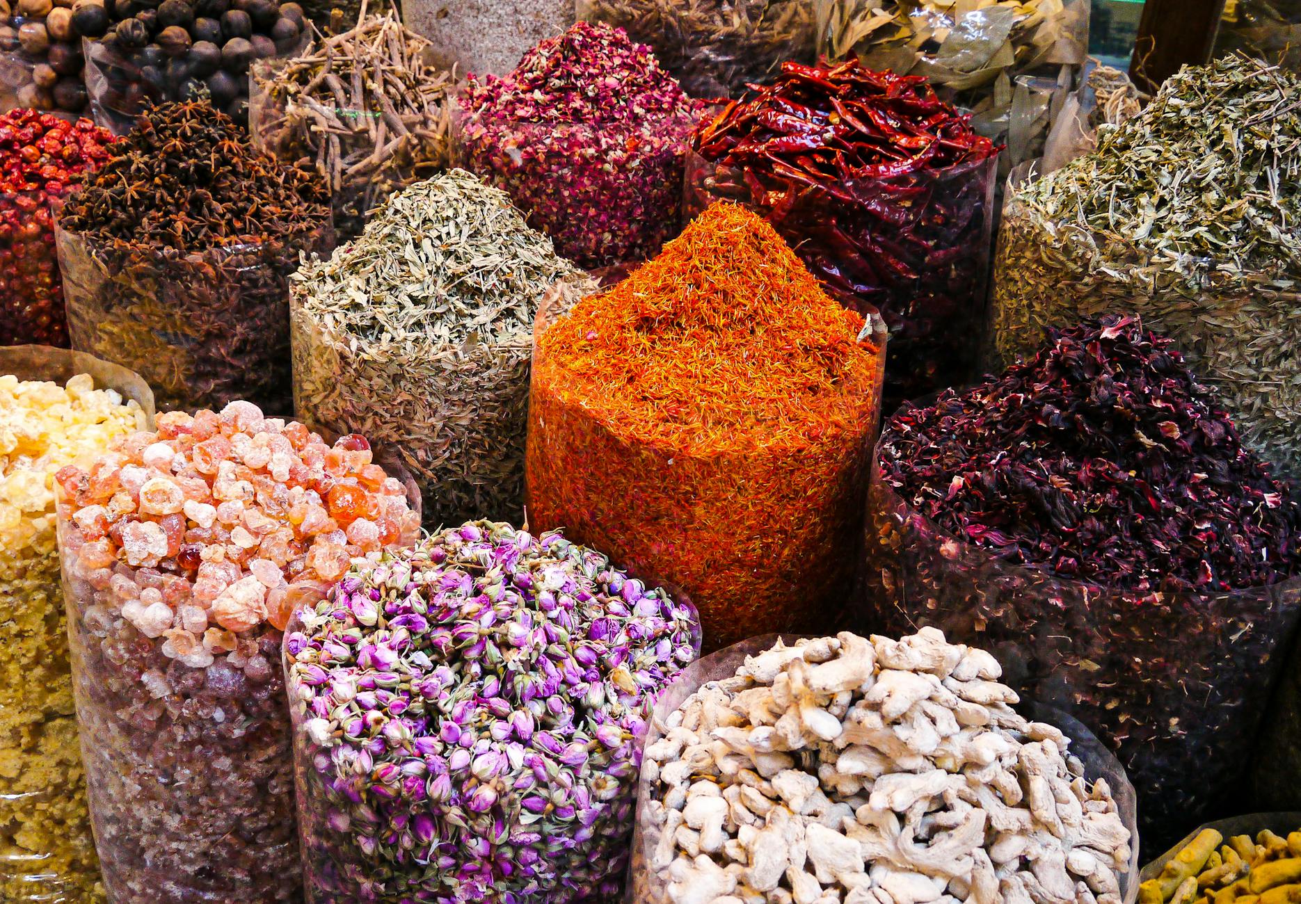 Colorful spices and dried flowers on display at Dubai's bustling spice souk market.