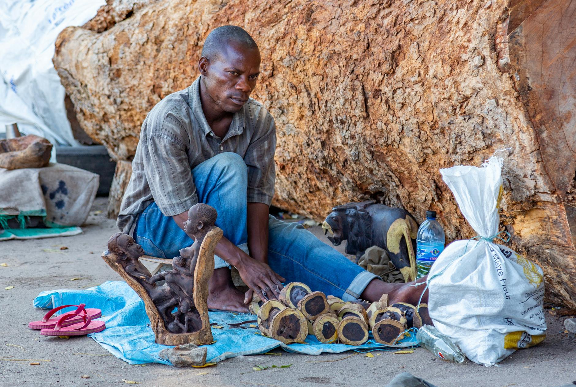 Artisan selling handcrafted wooden sculptures in Dar es Salaam, Tanzania.