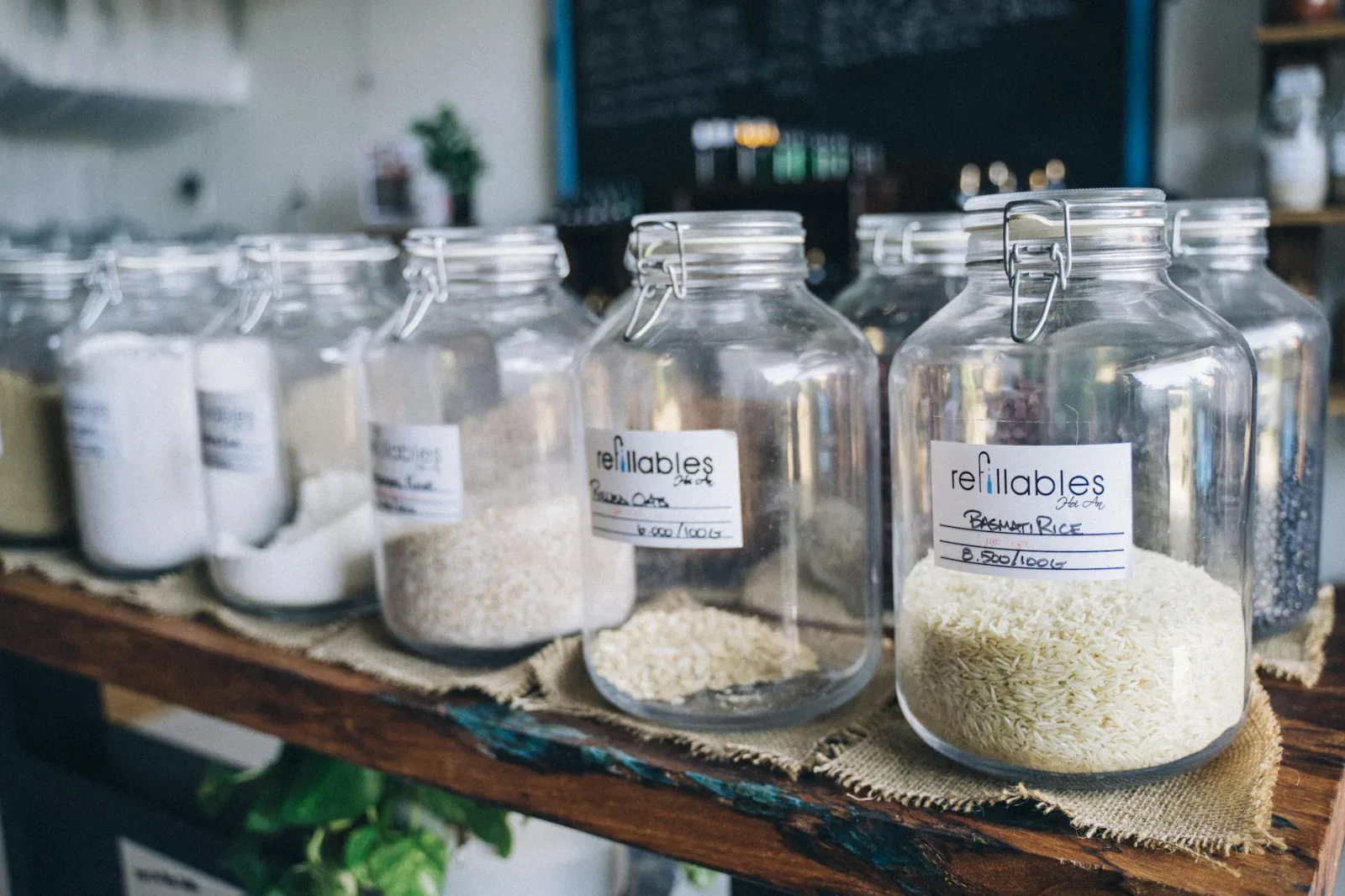 Glass jars in an eco-friendly refill shop filled with organic grains and items on display.