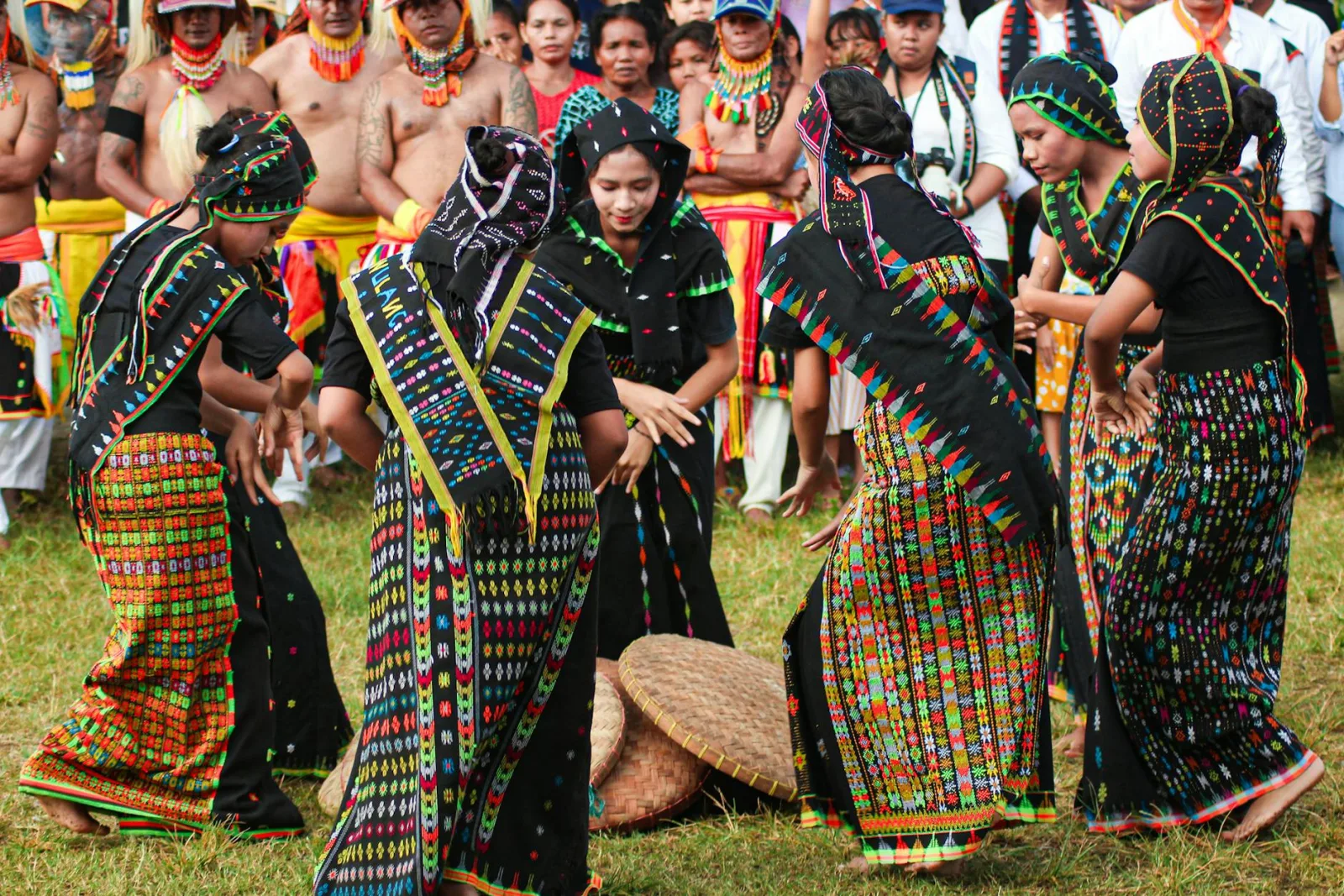 Women in colorful traditional attire perform a lively dance in Badjo, Indonesia.