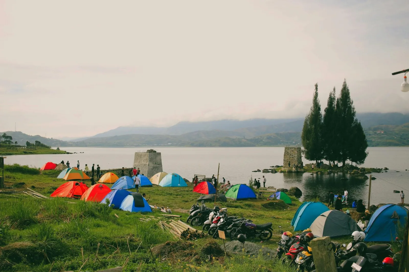 Vibrant tents and motorcycles by a serene lakeside, perfect for adventure seekers.