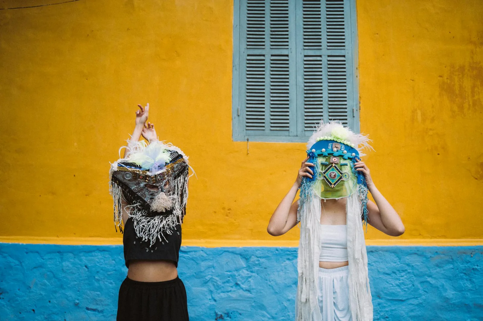 Women in vibrant costumes with artistic masks at a festival in Taiwan.