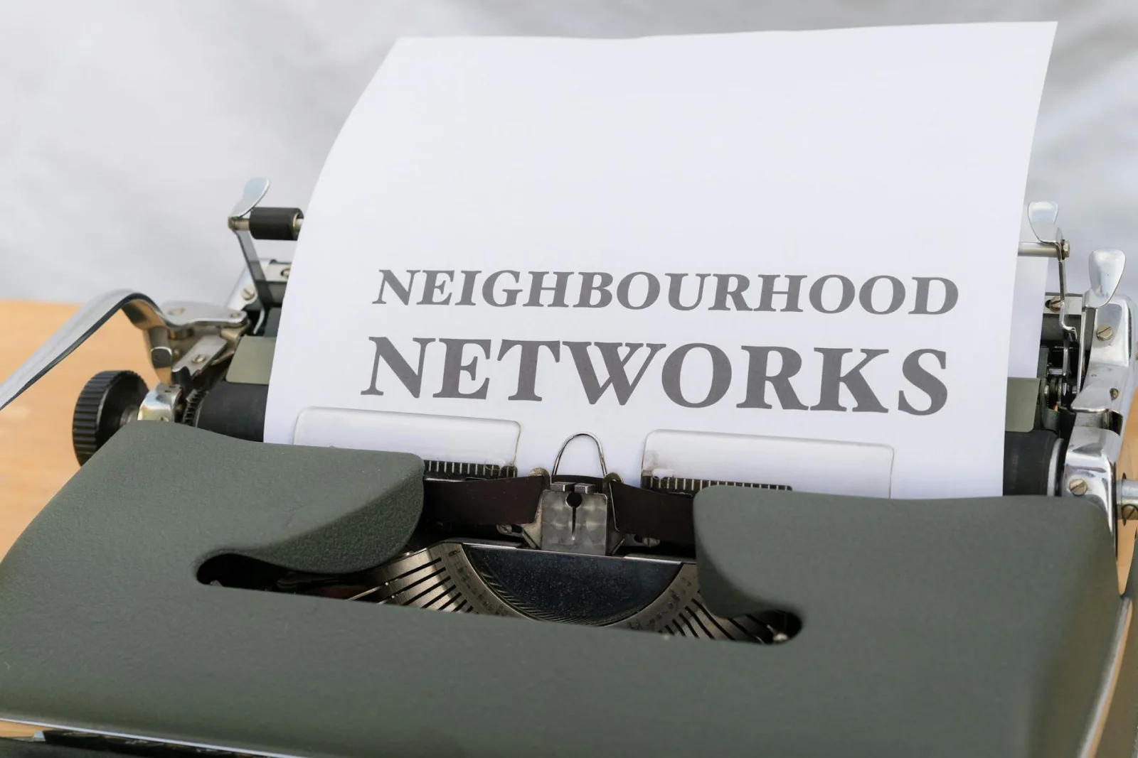 Close-up of a vintage typewriter with 'Neighbourhood Networks' text on paper.