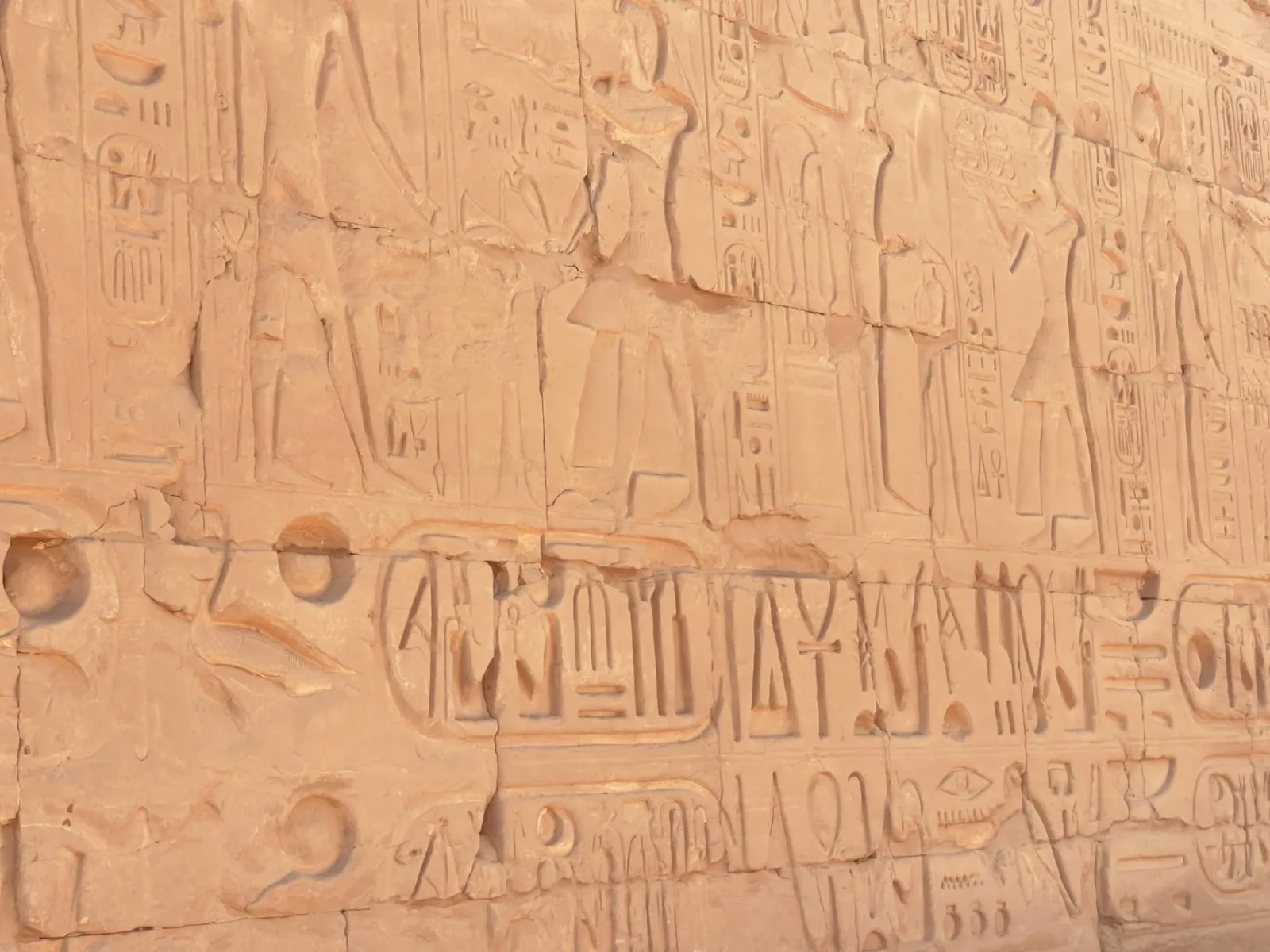 Intricate ancient Egyptian hieroglyphics carved into the historic Karnak Temple wall in Egypt.