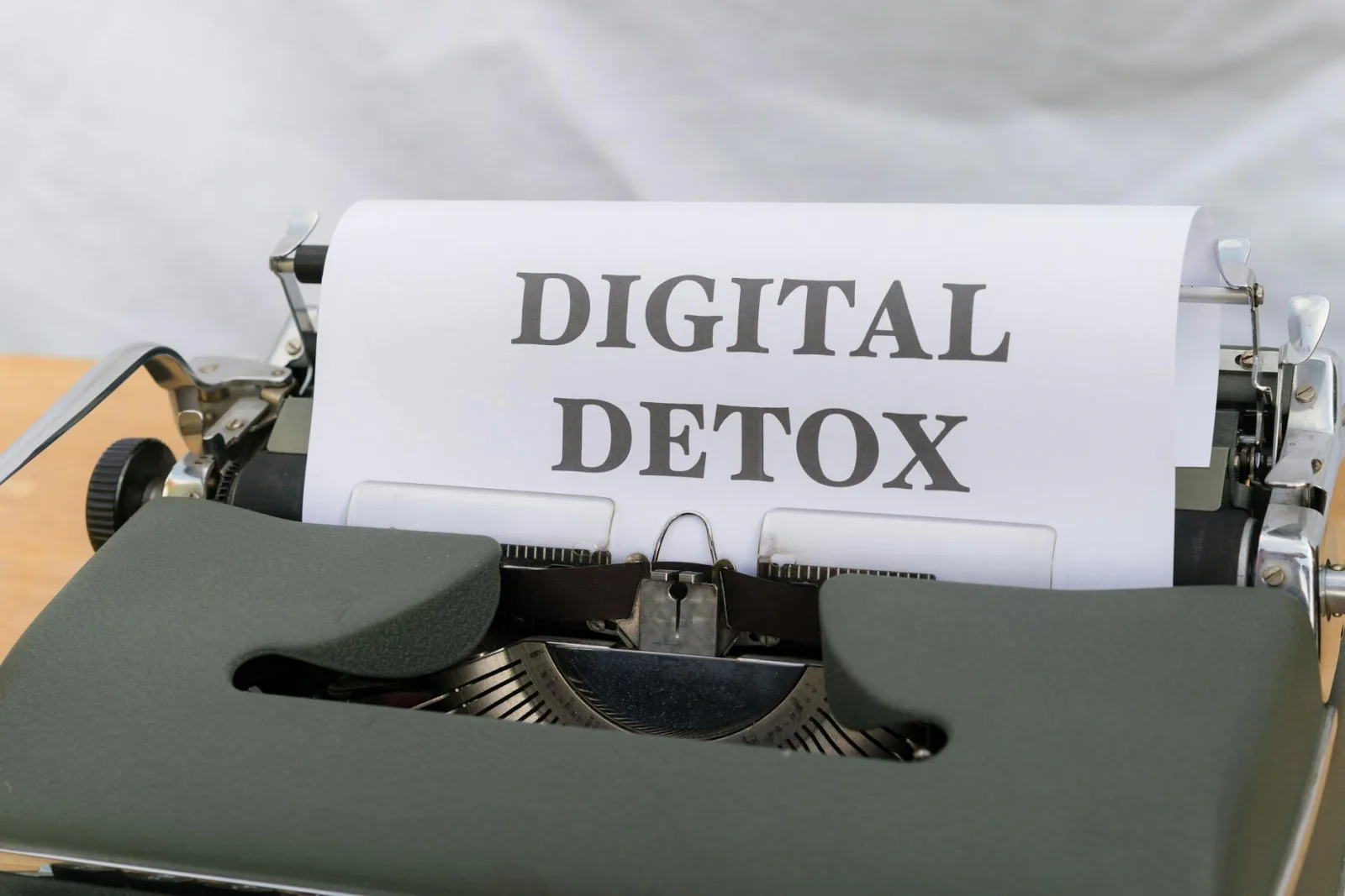 Close-up of a typewriter with paper showing 'Digital Detox', emphasizing a tech-free lifestyle.