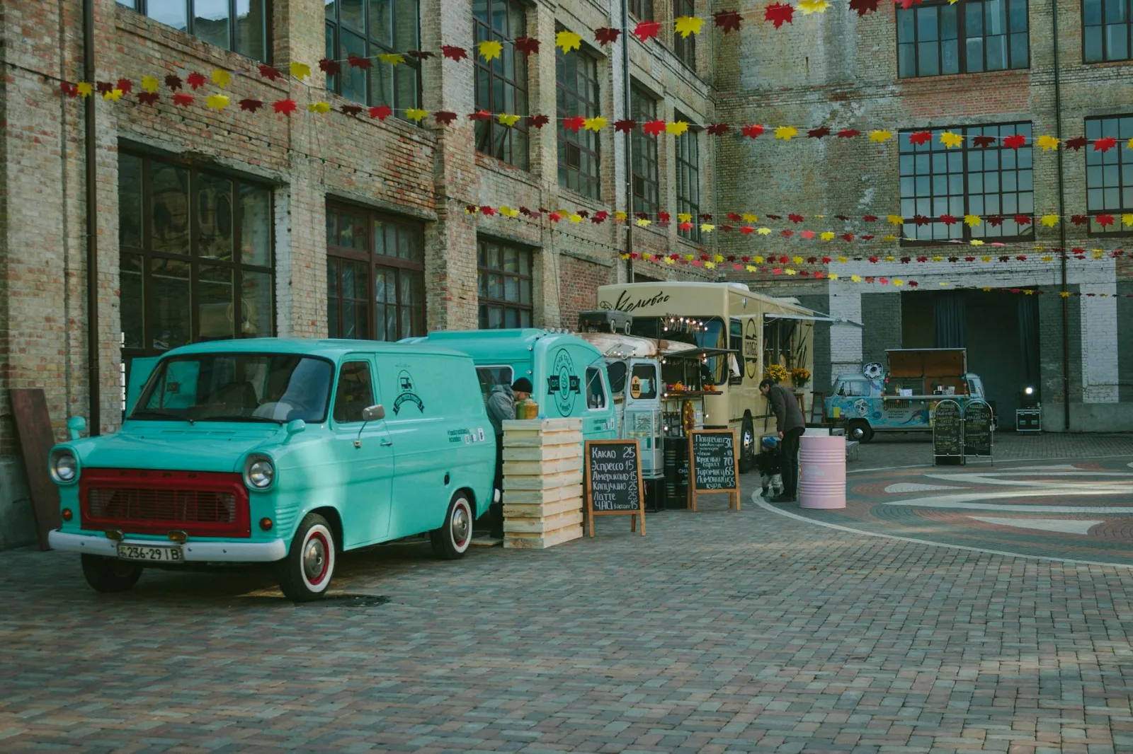 Colorful food trucks in a lively courtyard in Kyiv, showcasing urban street life and culinary diversity.