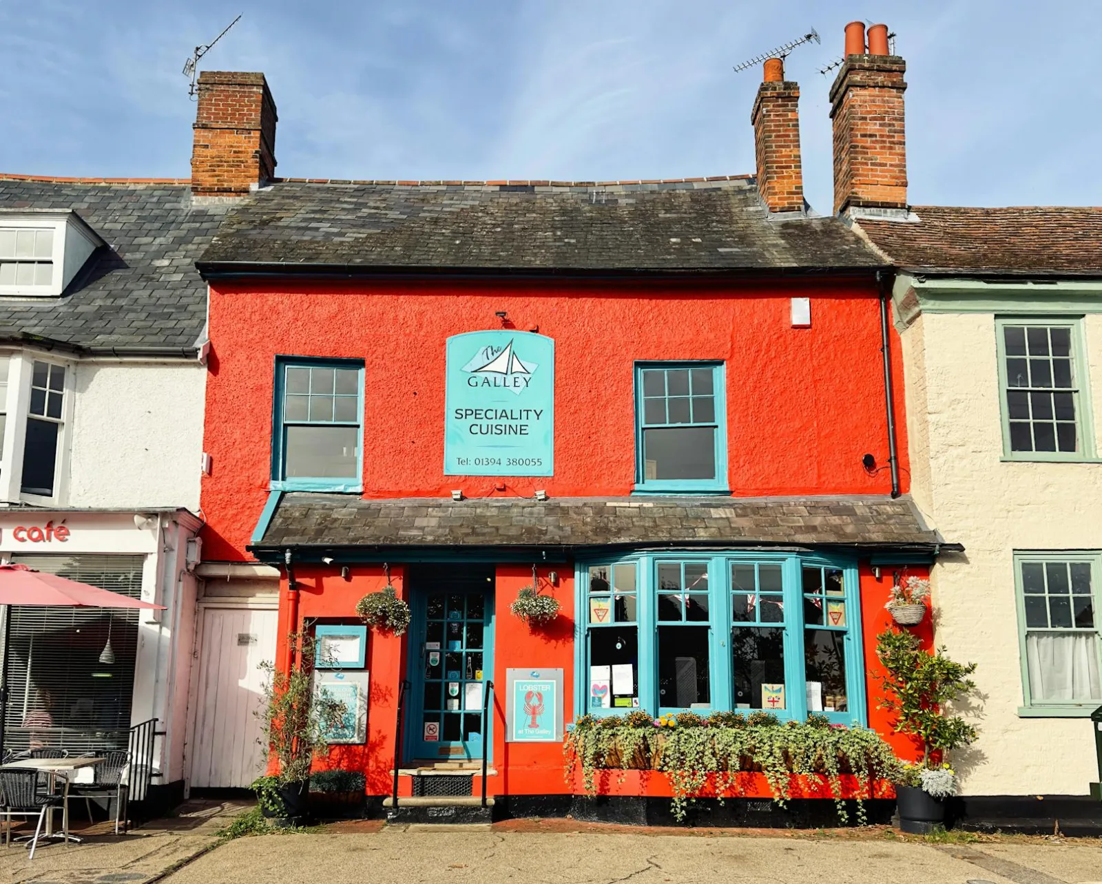 Historic red building featuring a restaurant in Woodbridge, known for its vibrant exterior and cozy charm.