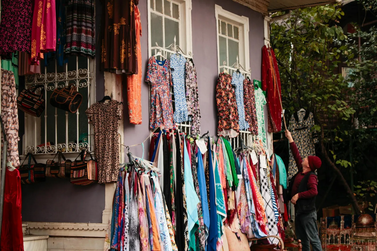 Vibrant outdoor display of fabrics and dresses at a marketplace in Bursa, Türkiye.