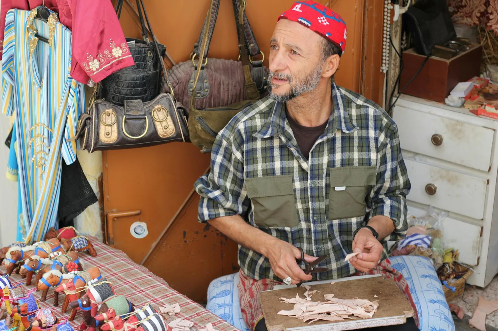 A skilled artisan crafting goods at a market stall in Tangier, Morocco.