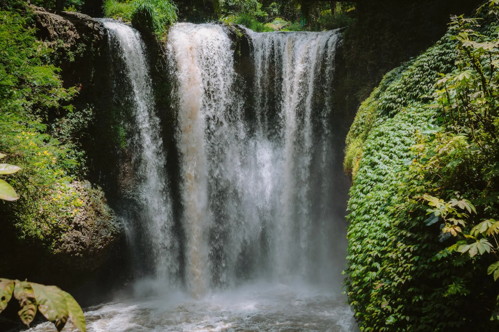 A breathtaking view of a waterfall in Lembang, surrounded by lush greenery and natural beauty.