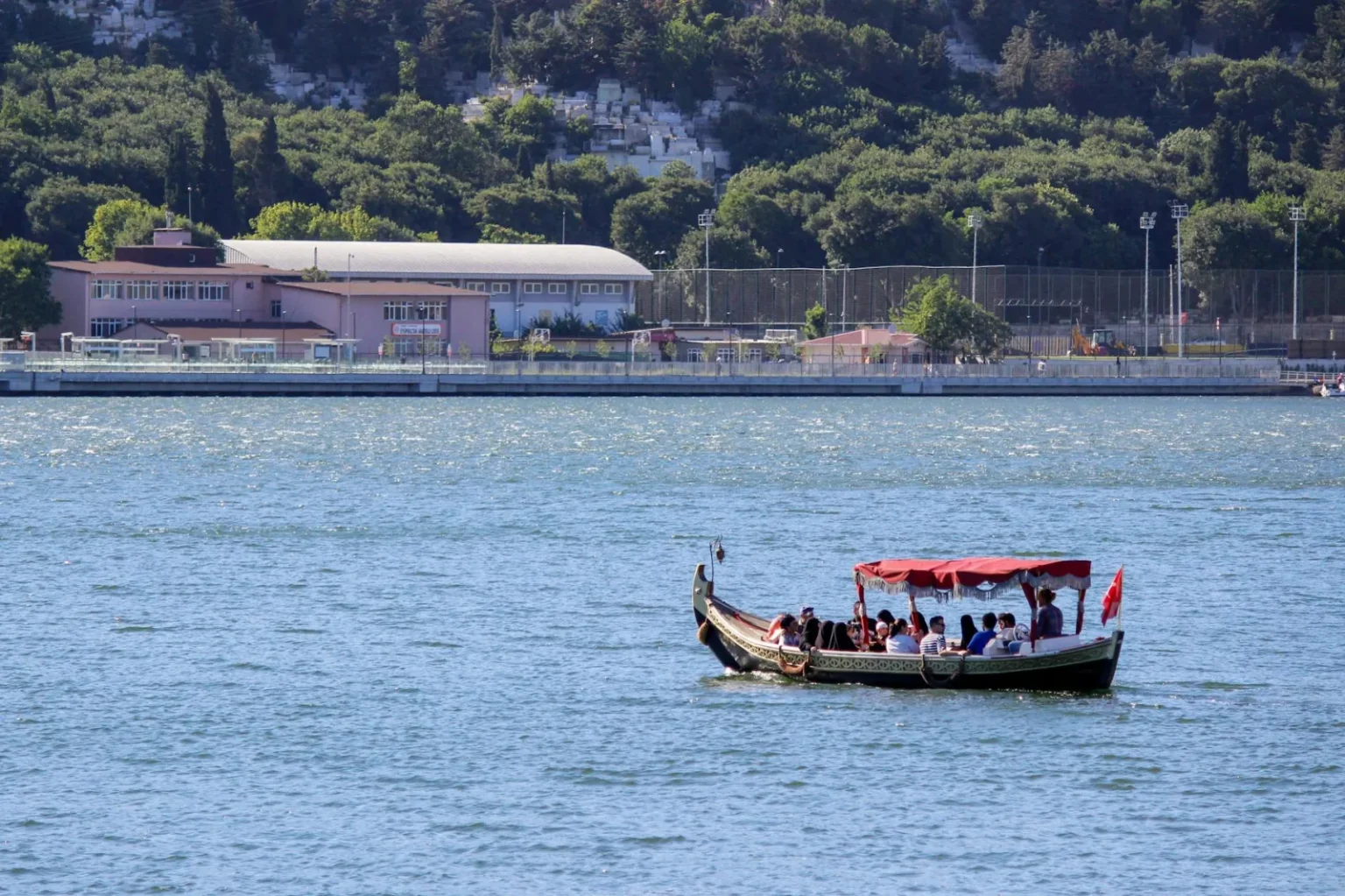 Tourists enjoying a boat ride on the Bosphorus in Istanbul with scenic views of the city.