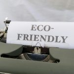 Typewriter printing 'Eco-Friendly' on paper, promoting sustainability.