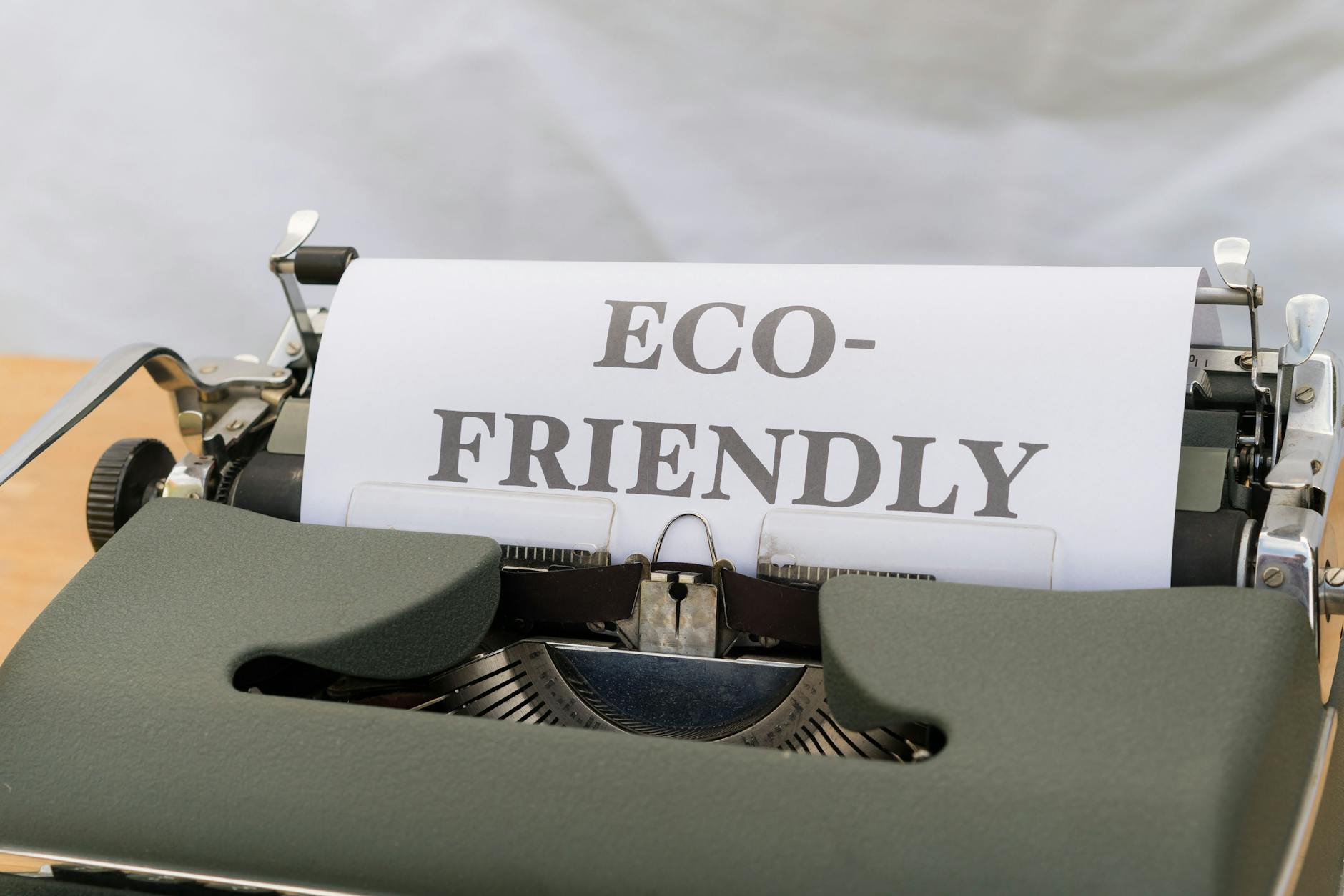 Typewriter printing 'Eco-Friendly' on paper, promoting sustainability.