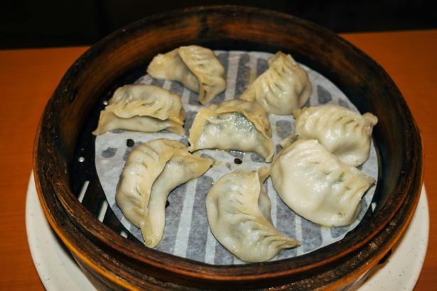 Close-up of traditional steamed dumplings in a bamboo basket, perfect for lunch or dinner.