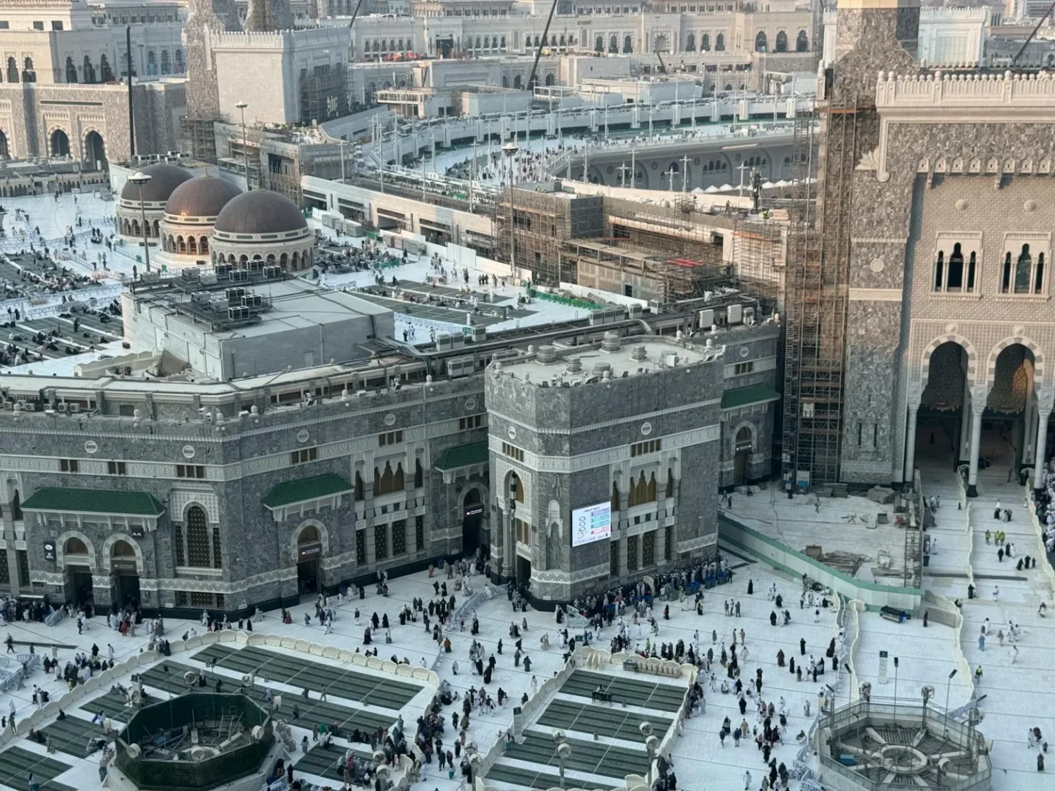 A stunning aerial view of the Masjid al-Haram, capturing the bustling courtyard in Mecca, Saudi Arabia.