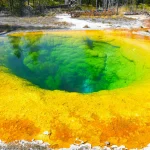 Colorful geothermal hot spring in Yellowstone's Morning Glory Pool with vivid hues.