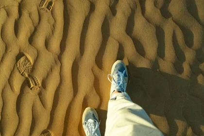 Explore the serene patterns of Oman's desert sands and footprints on an adventurous journey.