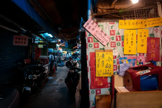 A lively Asian bazaar at night featuring colorful signs and scooters, creating an authentic local vibe.