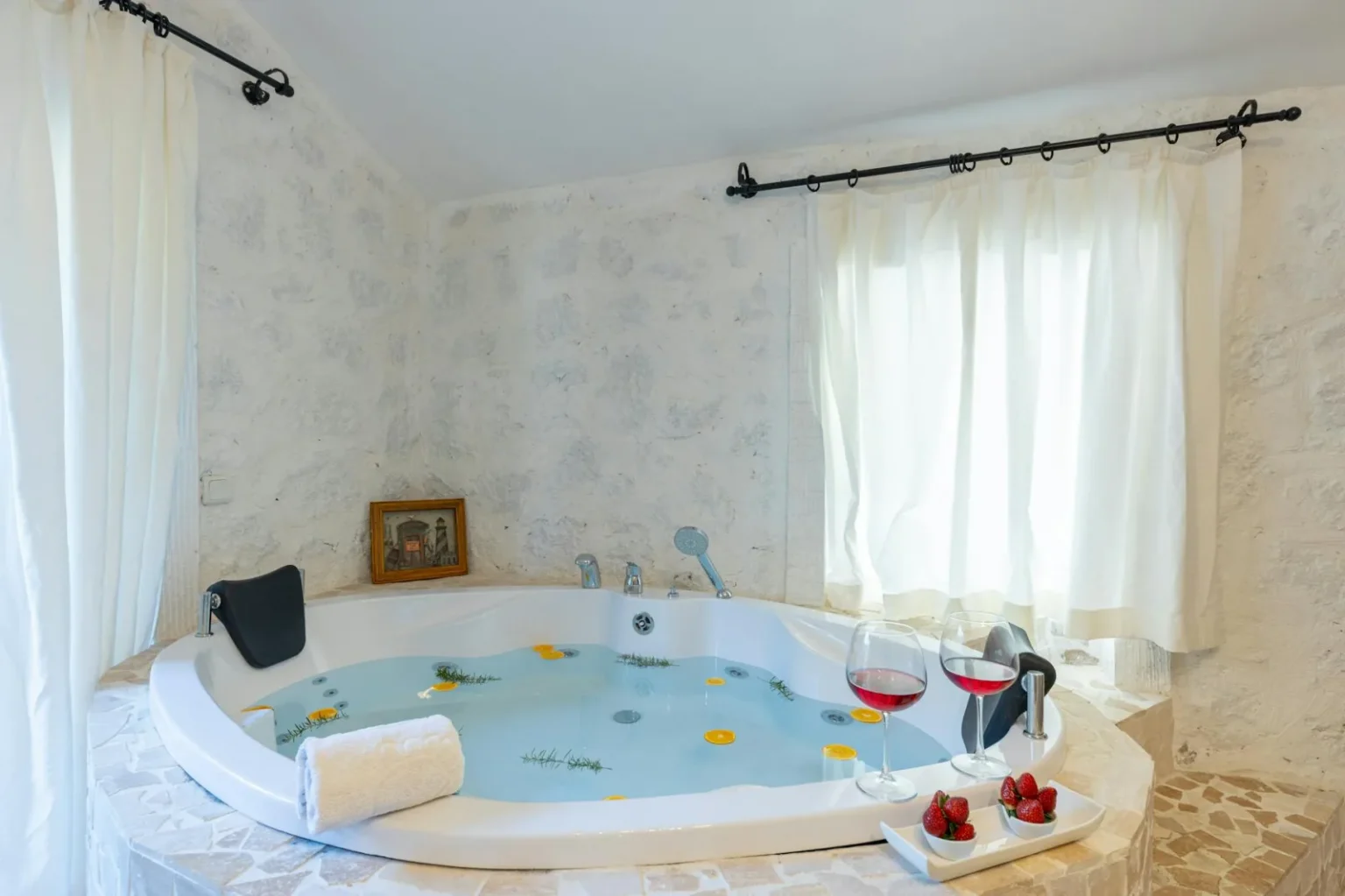 Enjoy relaxation in a luxury jacuzzi bath with wine and strawberries.