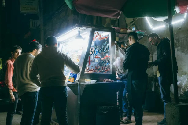A vibrant street food stall scene in Cairo, Egypt, bustling with activity at night.