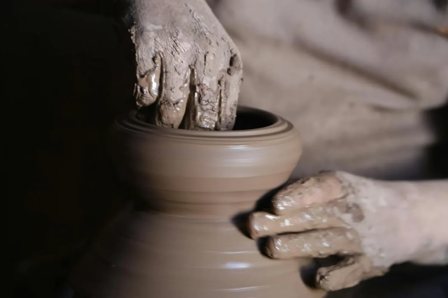 Detailed view of a potter's hands shaping clay pottery on a spinning wheel in Cairo, Egypt.
