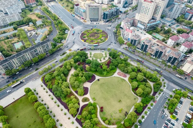Aerial view showcasing a city park and bustling roundabout in a vibrant urban area.