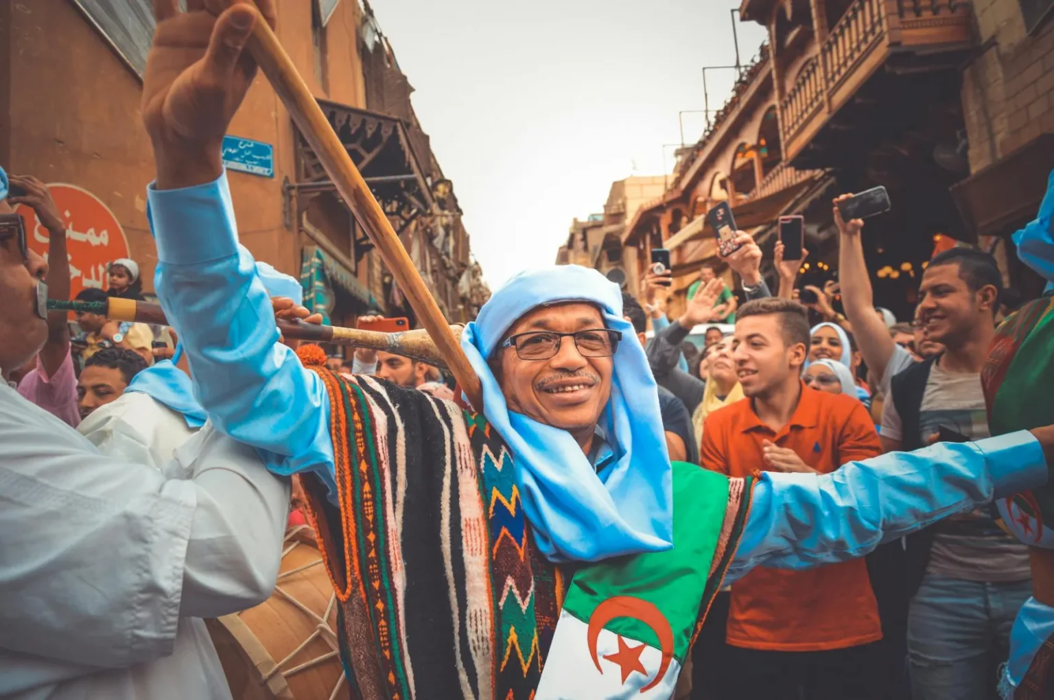Joyful street festival in Cairo showcasing Algerian cultural dance and music.