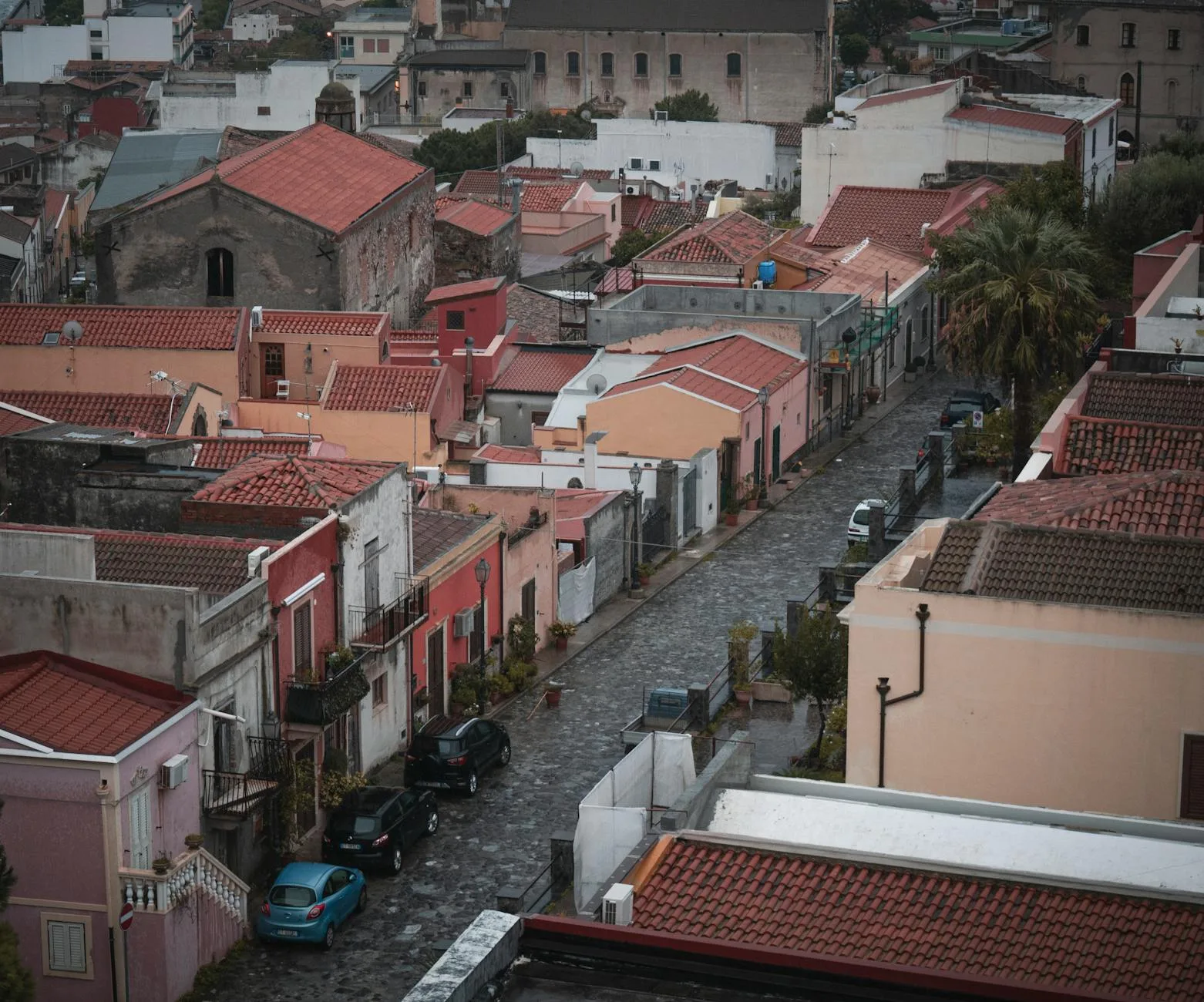 Charming aerial view of a Mediterranean village with cobblestone streets and red rooftops.