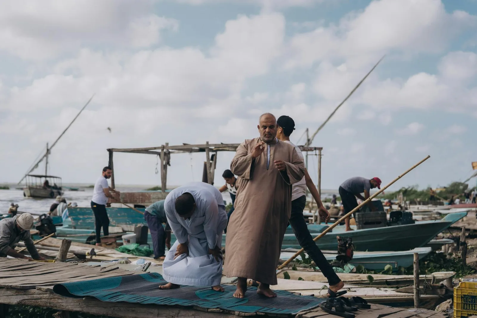 Fishermen gather at the Nile River near Cairo, engaging in daily life and prayer.