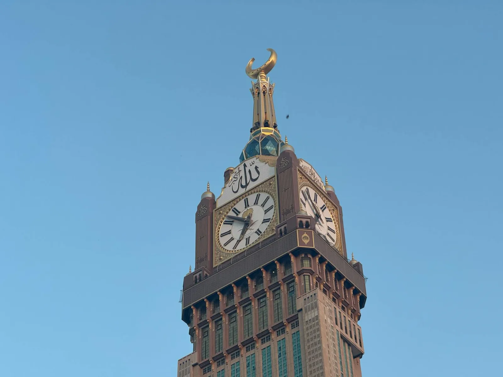 A stunning view of the Clock Tower at Abraj Al Bait, Mecca against a clear blue sky.