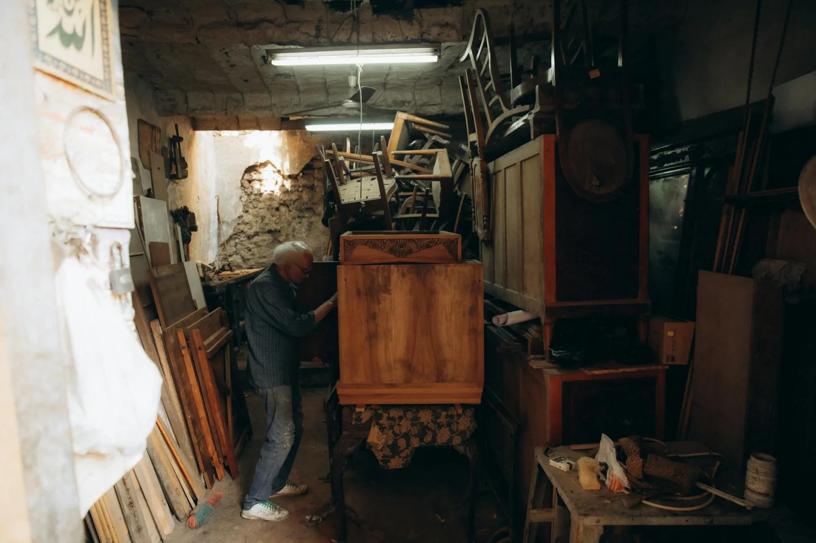 A skilled craftsman works on wooden furniture in a traditional Cairo workshop.
