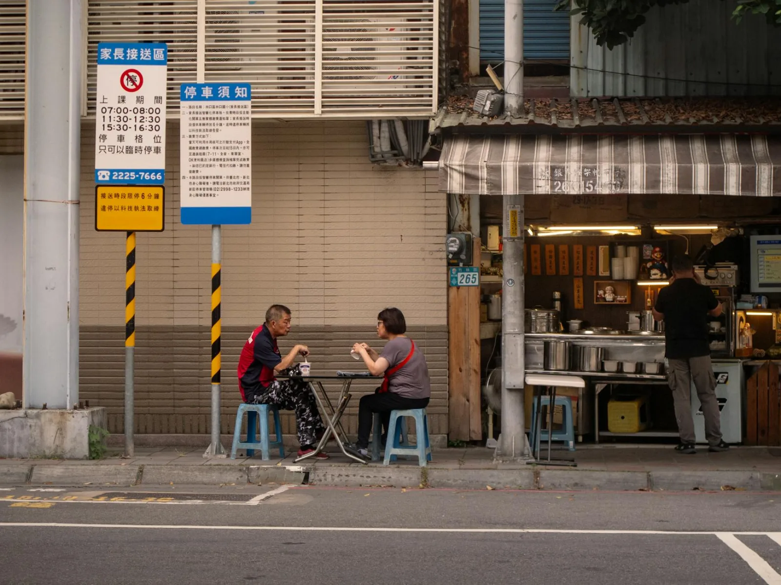 Two adults enjoying a meal at a street-side table in Taiwan.