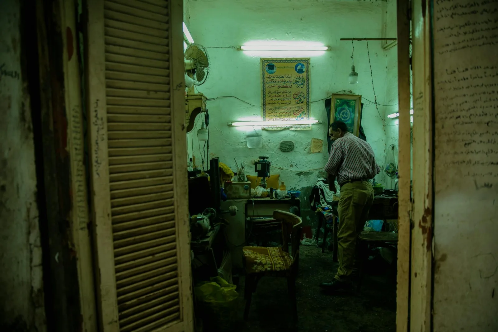 Atmospheric interior of an old shop in Cairo with a local man, vintage furnishings, and vibrant signage.