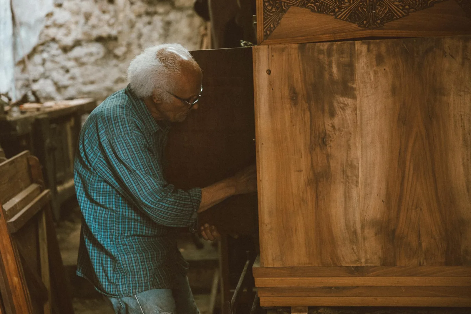 An elderly carpenter working meticulously in a vintage Cairo workshop, crafting wood furniture.