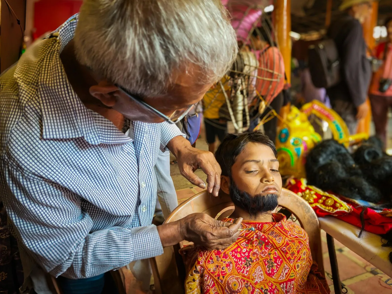 A child gets transformed into a mythical character at a vibrant festival in Kolkata, India.