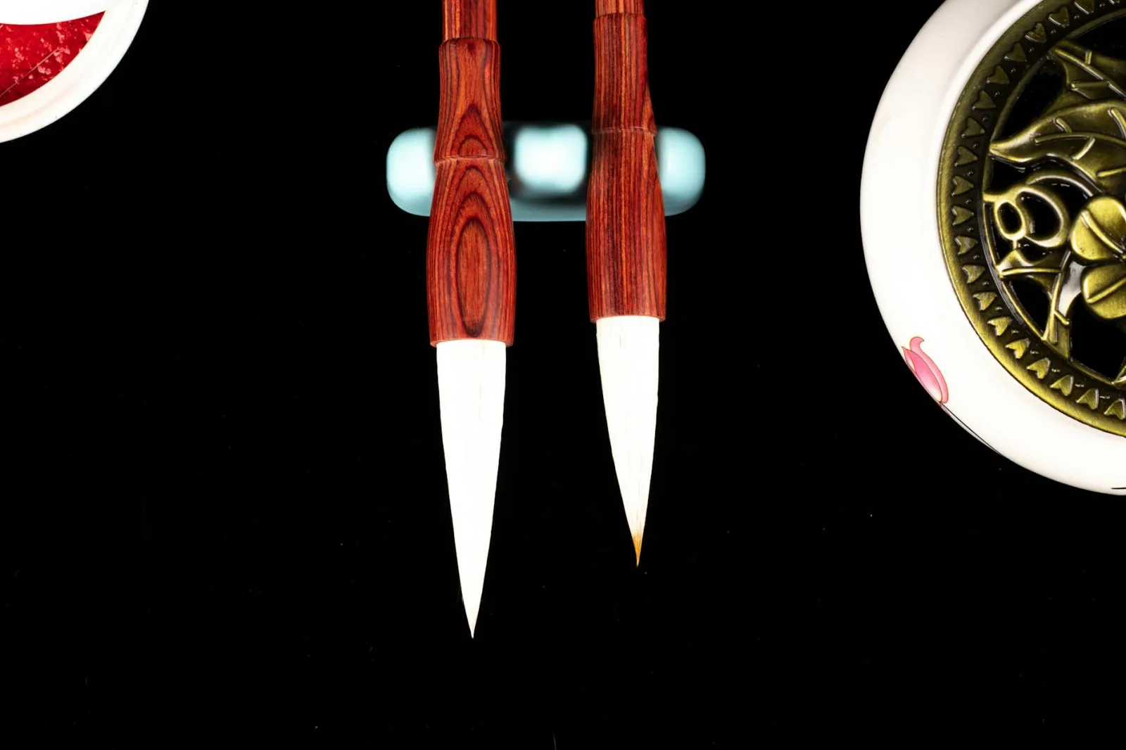 Top view of bright calligraphy brush pens with soft tips and bamboo shafts near decorative plant