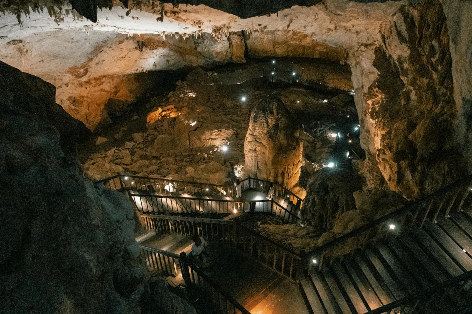 A stunning view of a cave with illuminated pathways and natural rock formations.