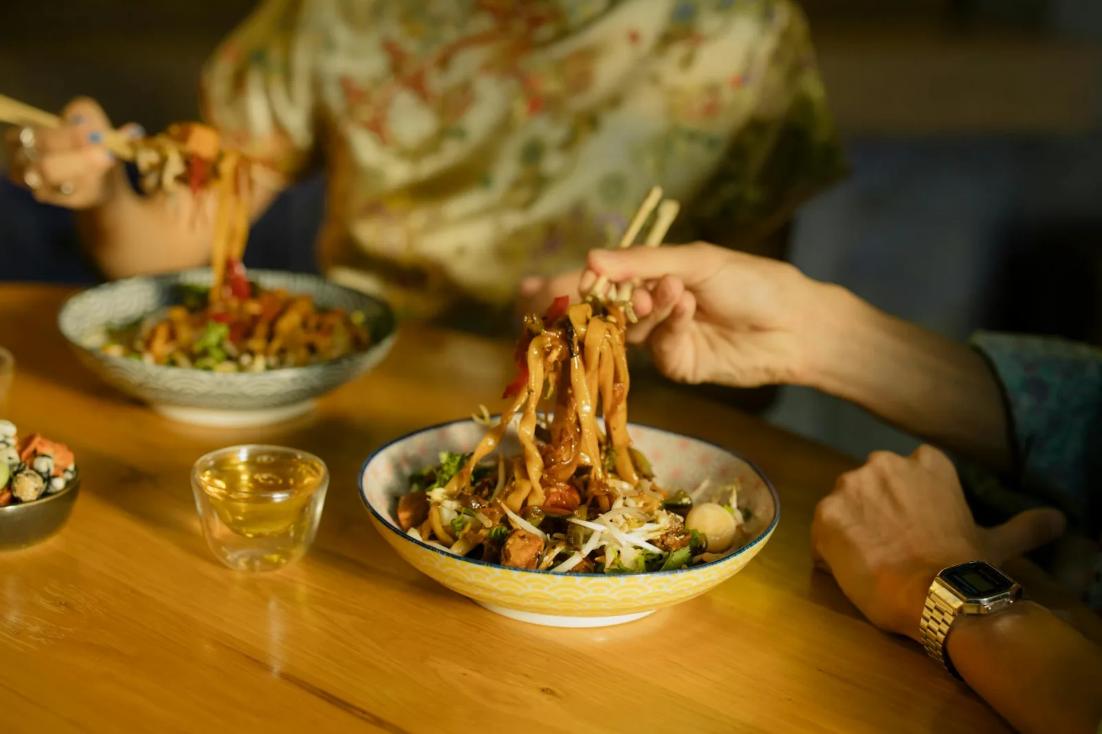 Close-up of delicious Asian noodles served with chopsticks in a cozy restaurant setting.